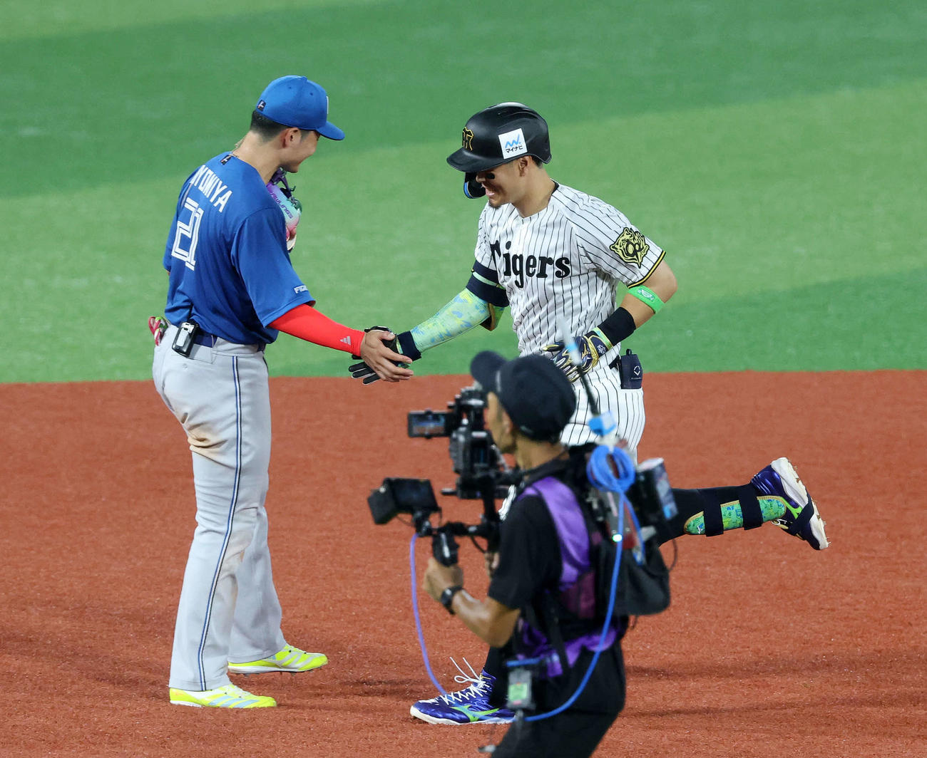 全セ対全パ　5回裏全セ1死、佐藤輝（右）は右越えソロ本塁打を放ち清宮とタッチ（撮影・鈴木正人）