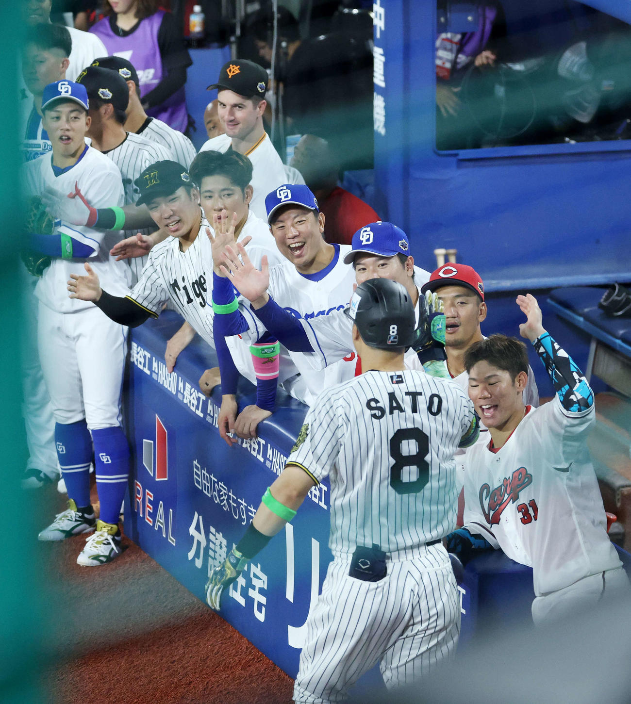 全セ対全パ　5回裏全セ1死、佐藤輝は右越えソロ本塁打を迎える選手たち（撮影・鈴木正人）