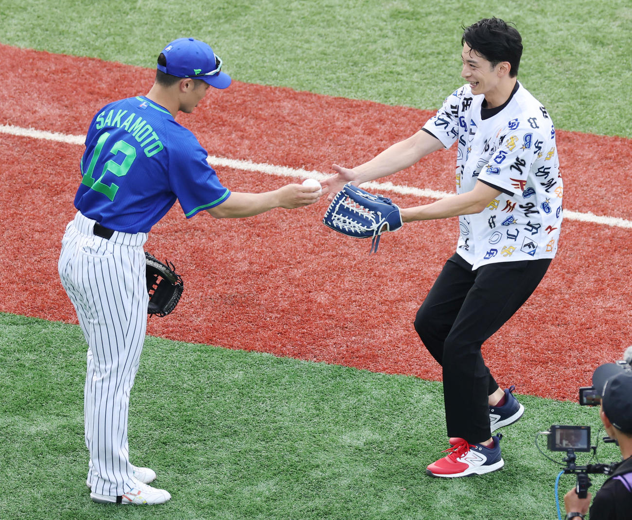 全セ対全パ　ファーストピッチセレモニーを終え全セ坂本（左）にボールをもらう入江陵介氏（撮影・野上伸悟）