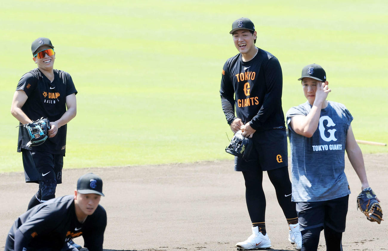 ノック中、笑顔の巨人岡本（右奥）（撮影・浅見桂子）