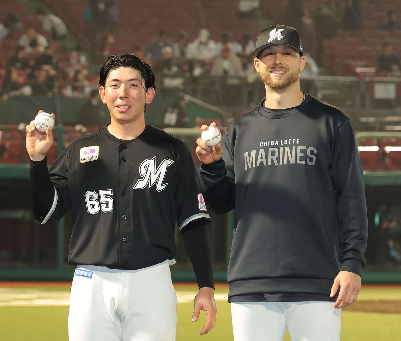 楽天に勝利し、記念球を手に写真に納まる、プロ初本塁打を放ったロッテ寺地（左）と来日初勝利のボス＝2025年4月18日