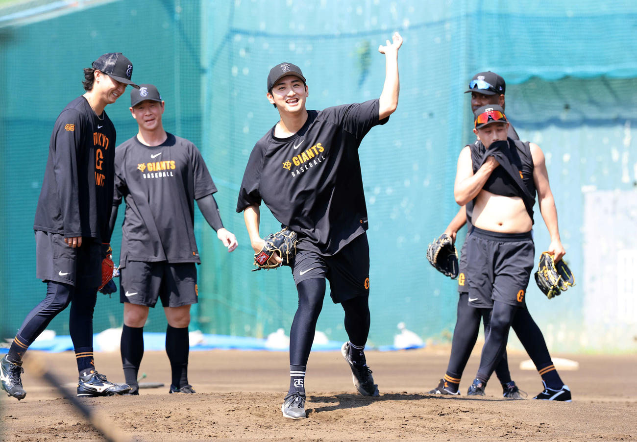25年7月25日　炎天下のノックで、汗をぬぐう選手の中でさわやかな笑顔を見せる巨人横川（中央）（撮影・浅見桂子）