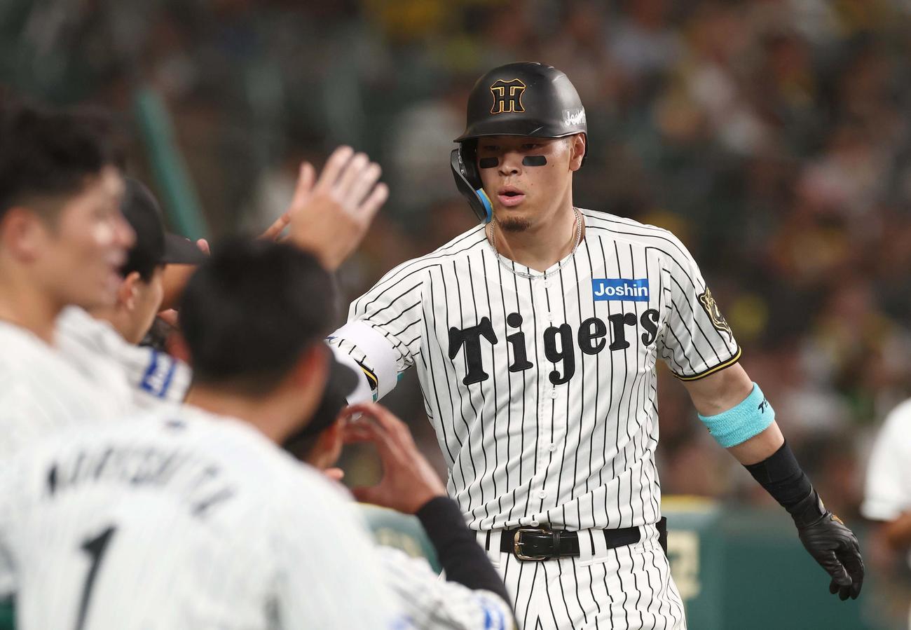阪神対DeNA 6回裏阪神1死、ソロ本塁打を放った佐藤輝はナインとハイタッチをする（撮影・上田博志）