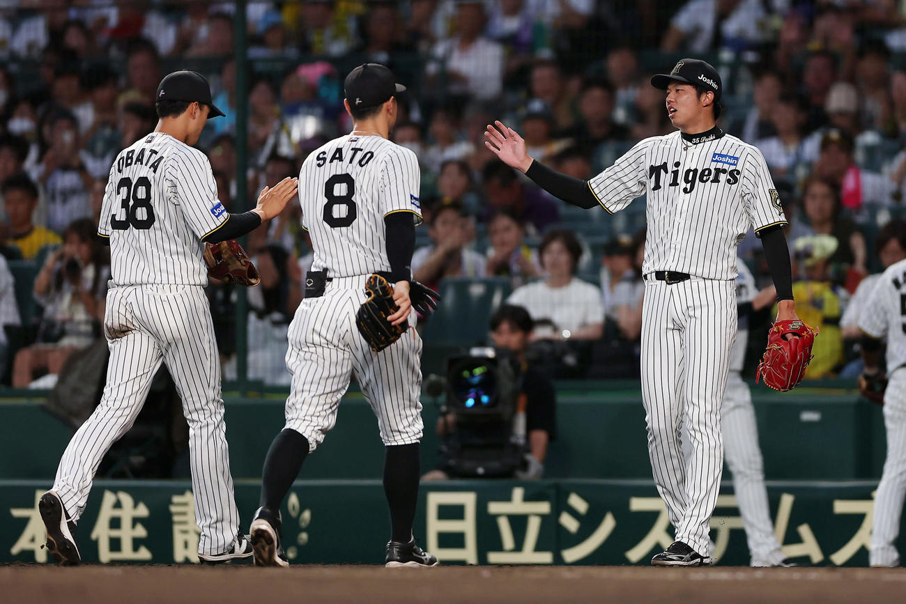 阪神対DeNA 4回表のDeNA打線を抑え、好守を見せた小幡（左）とタッチを交わす才木（撮影・前田充）