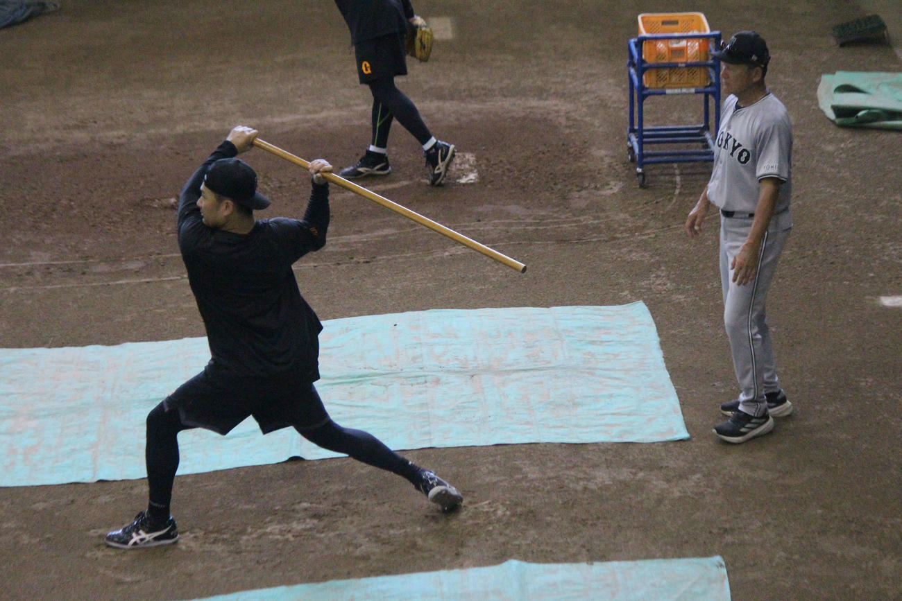 田中は木棒を使いフォームを確認。右は久保コーチ