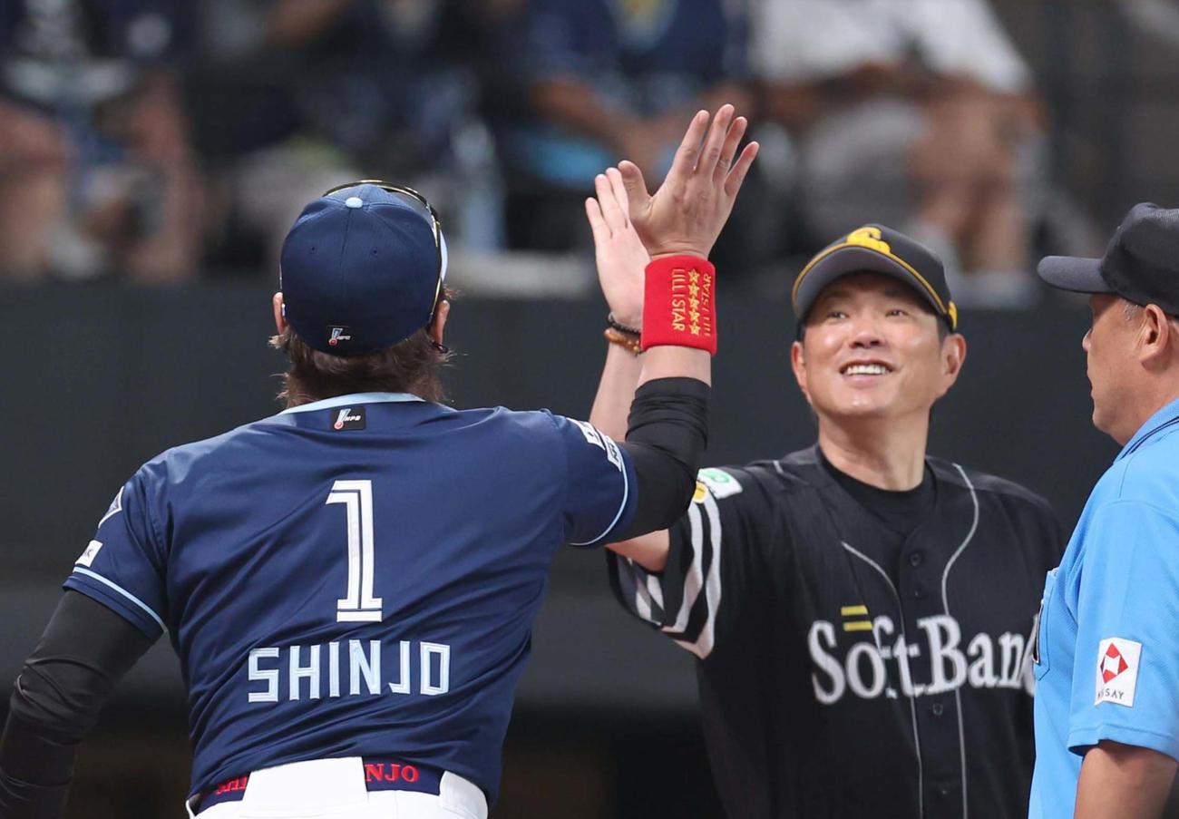 日本ハム対ソフトバンク　メンバー表交換で小久保監督とハイタッチする新庄監督（撮影・黒川智章）