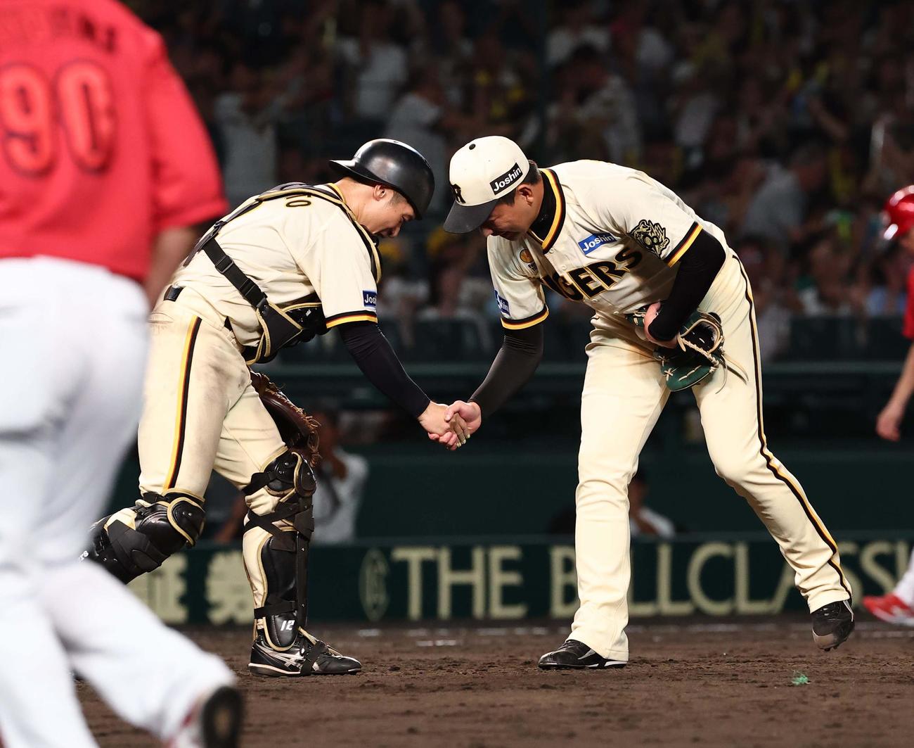 阪神対広島　広島に勝利し坂本（左）と握手を交わす岩崎（撮影・上田博志）