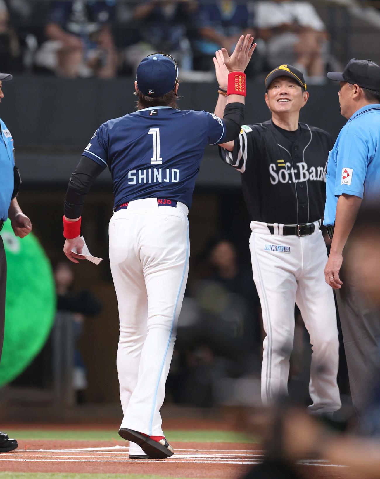 日本ハム対ソフトバンク　メンバー表交換で小久保監督とハイタッチする新庄監督（撮影・黒川智章）