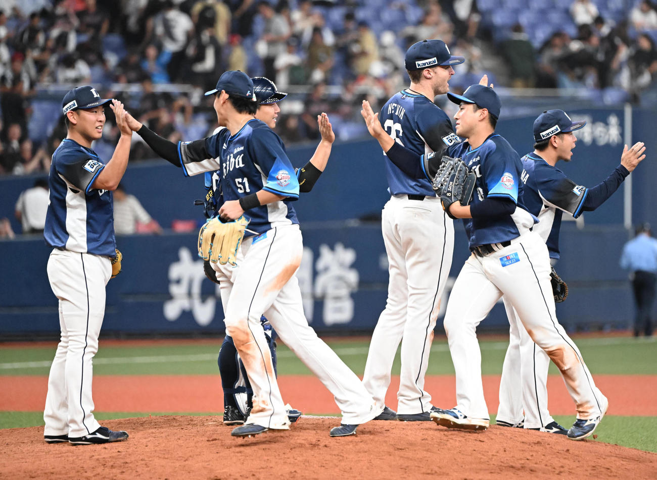 オリックス対西武　プロ初セーブをマークした西武山田（左）ははナインとタッチする（撮影・和賀正仁）