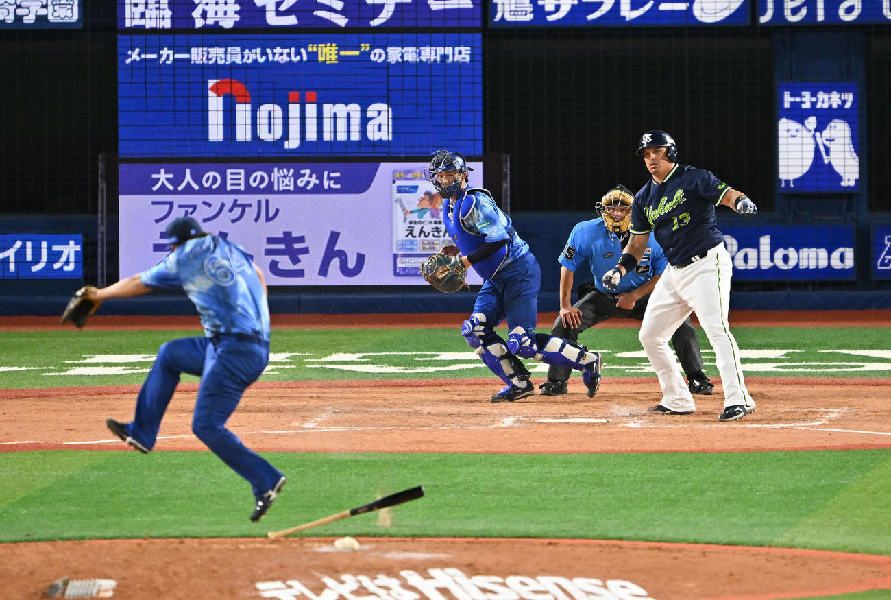 DeNA対ヤクルト　8回表ヤクルト2死一、二塁、空振り三振に倒れたオスナ（後方）のバットをよける中川虎（撮影・滝沢徹郎）　