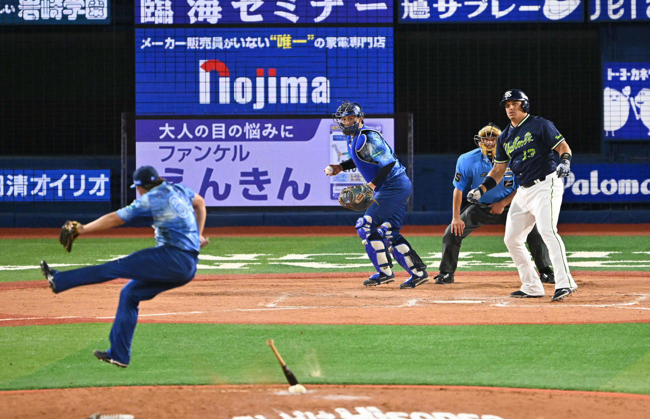DeNA対ヤクルト　8回表ヤクルト2死一、二塁、空振り三振に倒れたオスナ（後方）のバットをよける中川虎（撮影・滝沢徹郎）　