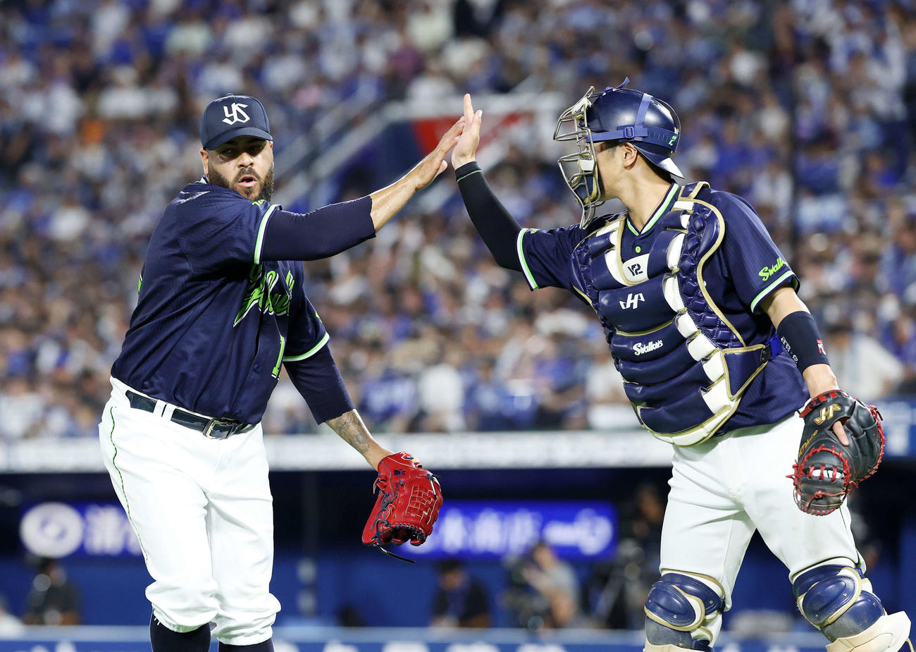 DeNA対ヤクルト　5回裏、DeNAの攻撃を抑えタッチするヤクルトアビラ（左）と古賀（撮影・鈴木正人）