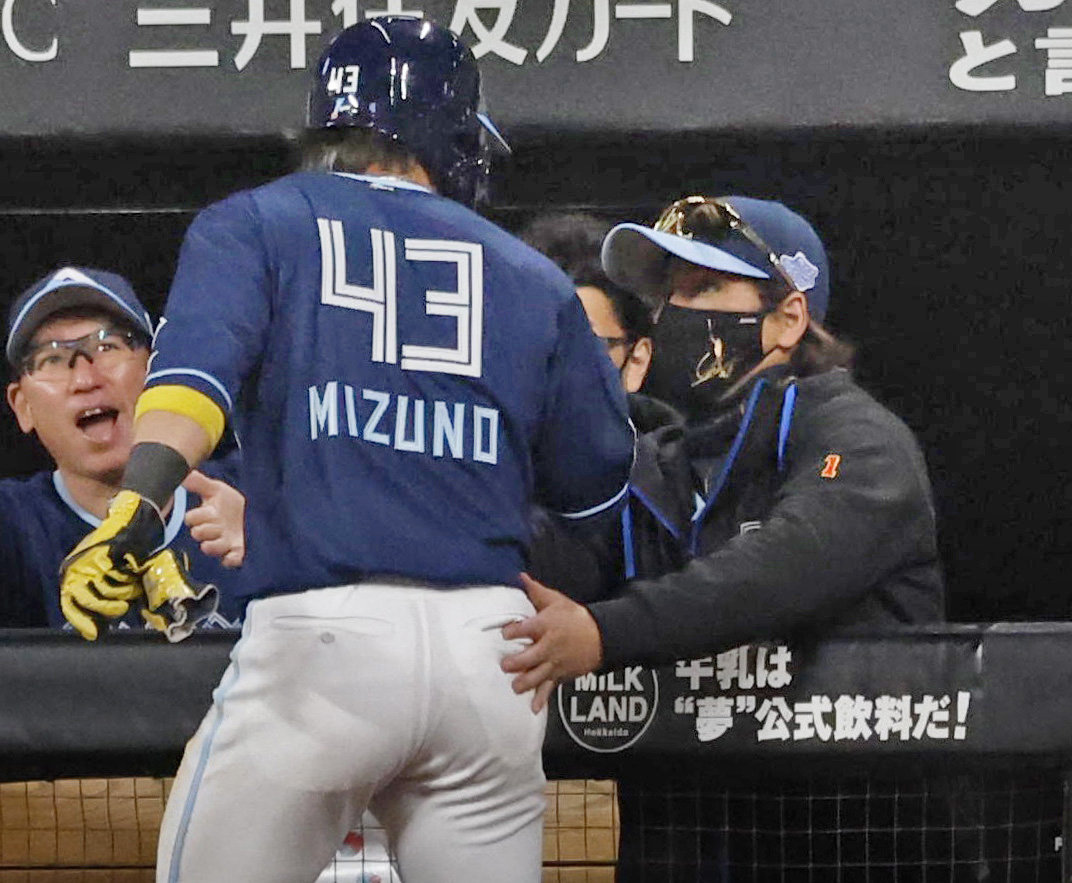 5回、水谷の中前打で生還した水野を迎える日本ハム・新庄監督（右）（共同）