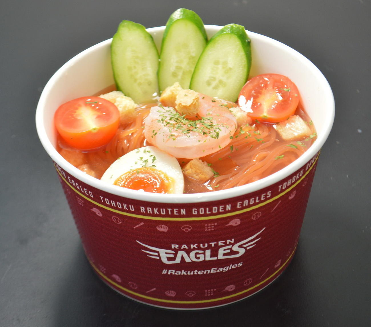 トマト冷麺　夏にぴったりの冷麺にトマトを練り込んだ色鮮やかな麺にクルトンのアクセントも。（球団提供）