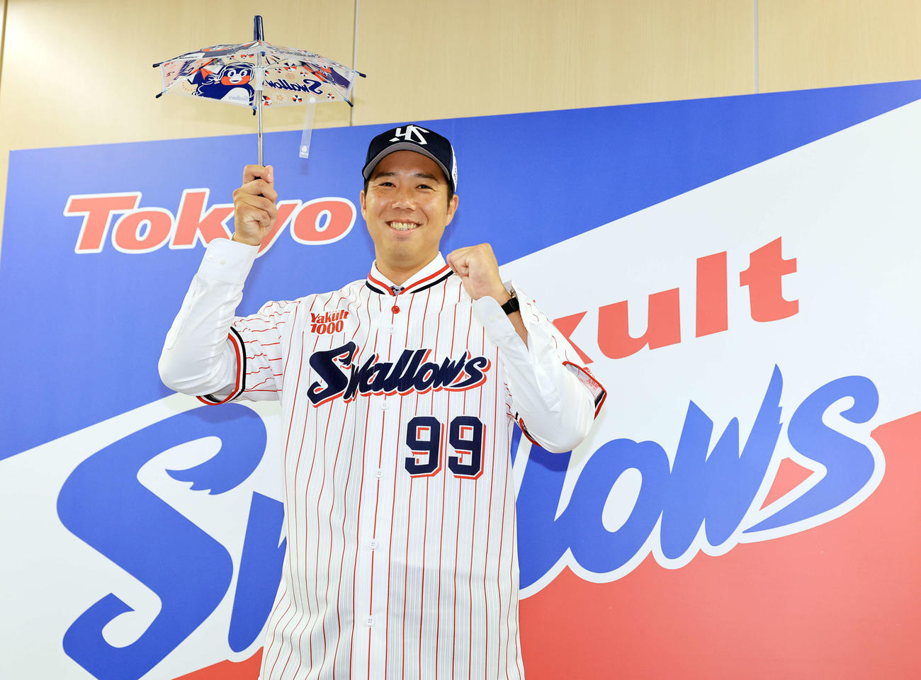 ヤクルト入団会見で傘を手に笑顔でポーズをとる青柳（撮影・浅見桂子）