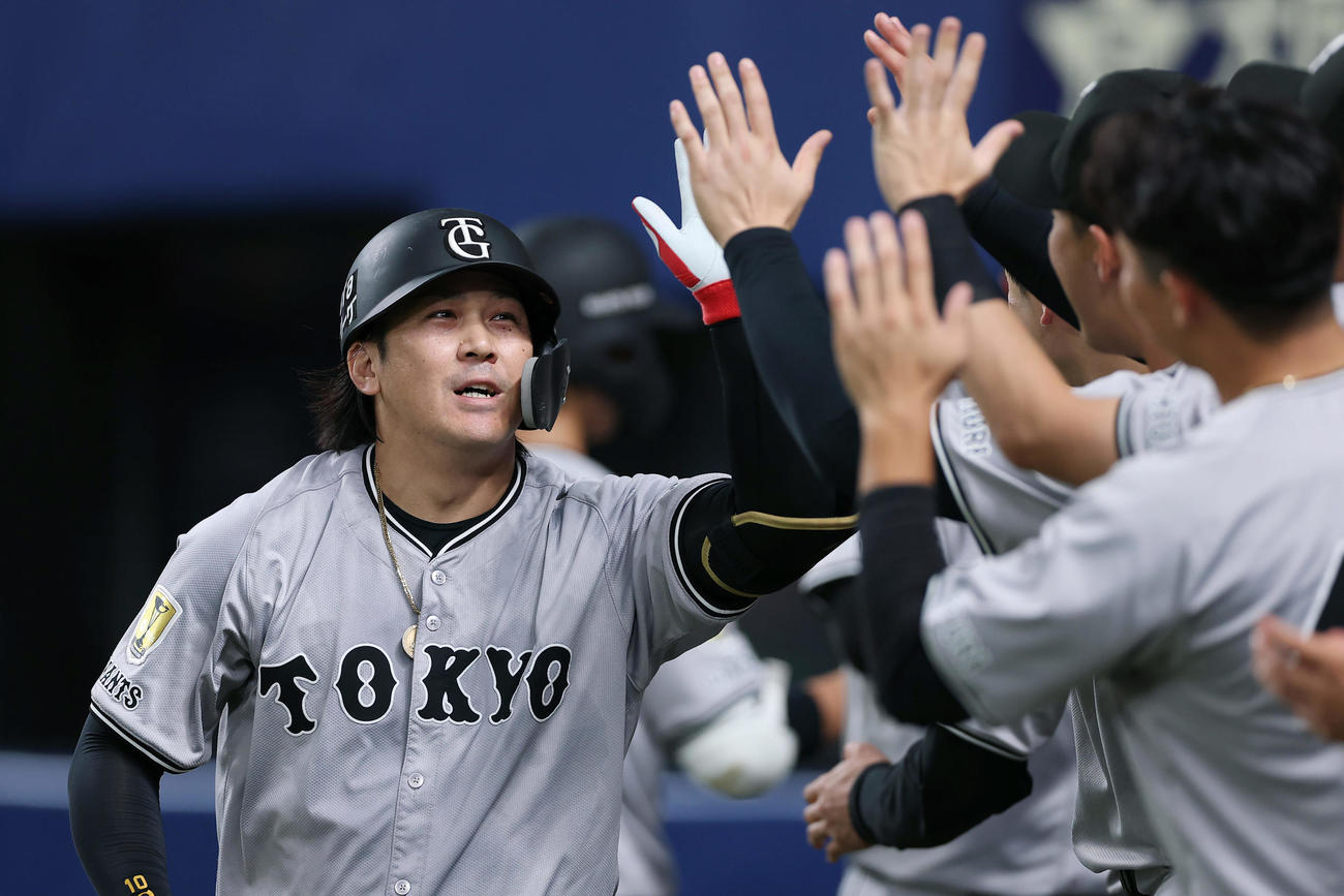 中日対巨人　4回表巨人2死二、三塁、勝ち越しの左越え3点本塁打を放ち、ナインに迎えられる甲斐（撮影・前田充）