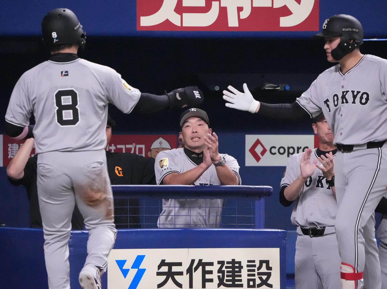 中日対巨人　1回表巨人1死三塁、阿部監督（中央）は泉口の左犠飛で生還した丸を迎える（撮影・森本幸一）