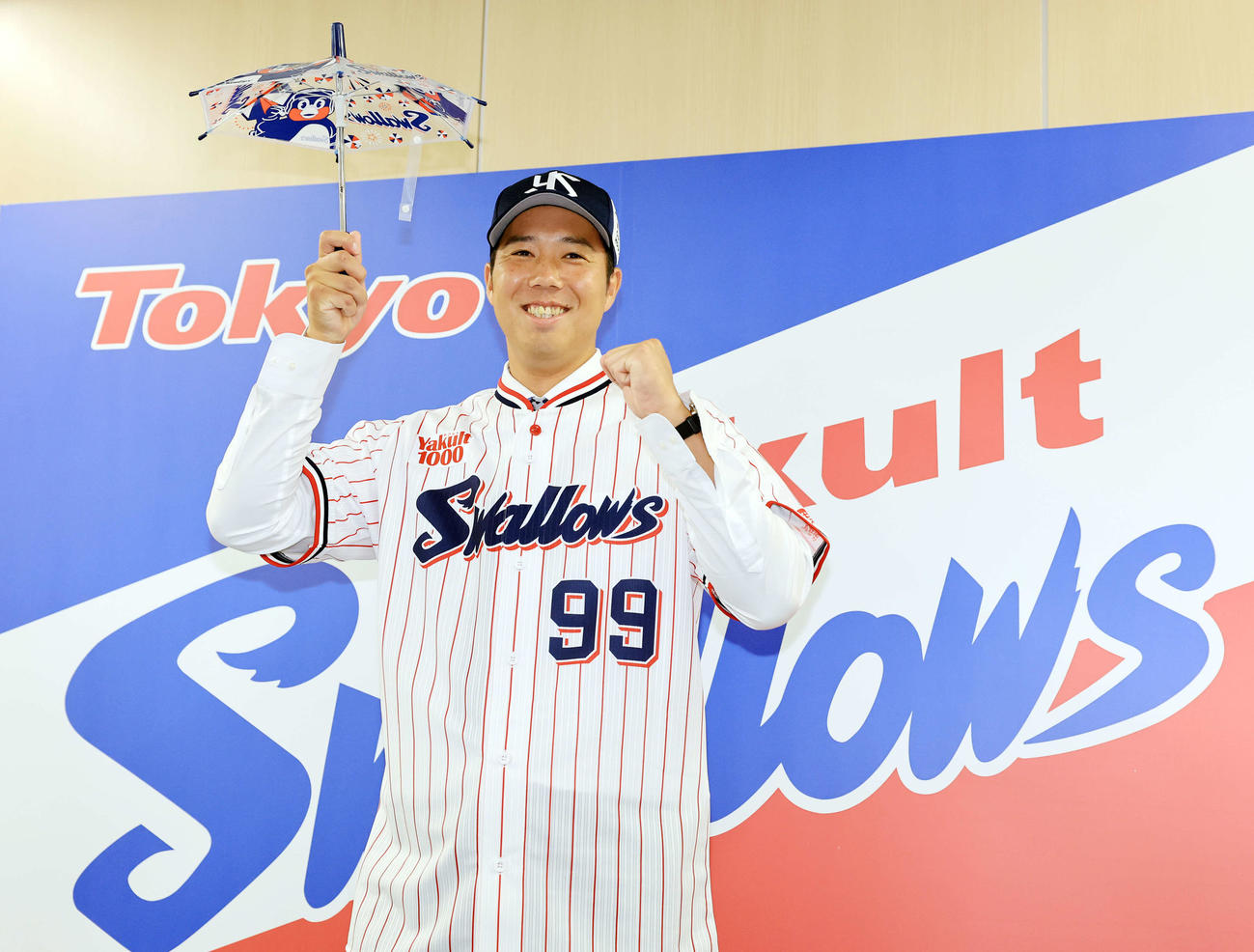 ヤクルト入団会見で傘を手に笑顔でポーズをとる青柳（撮影・浅見桂子）