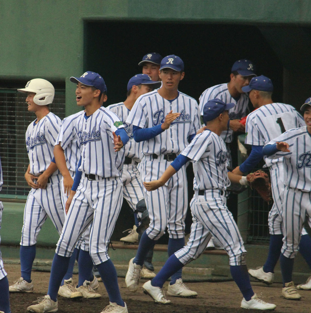 ベンチ前でチームメートを笑顔で迎える立正大立正・内海瑛太投手（左から2人目）