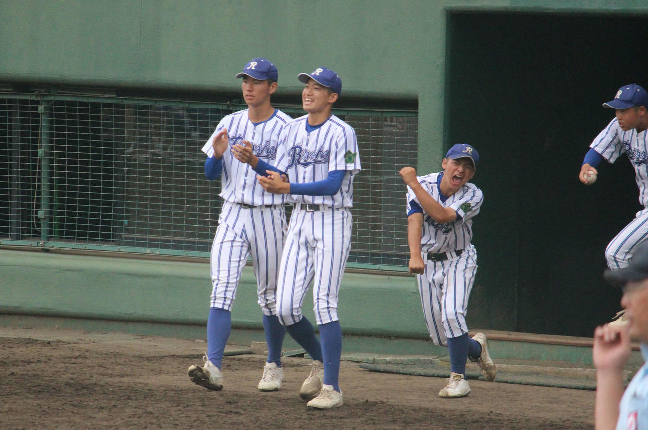 ベンチ前でチームメートを笑顔で迎える立正大立正・内海瑛太投手（左から2人目）