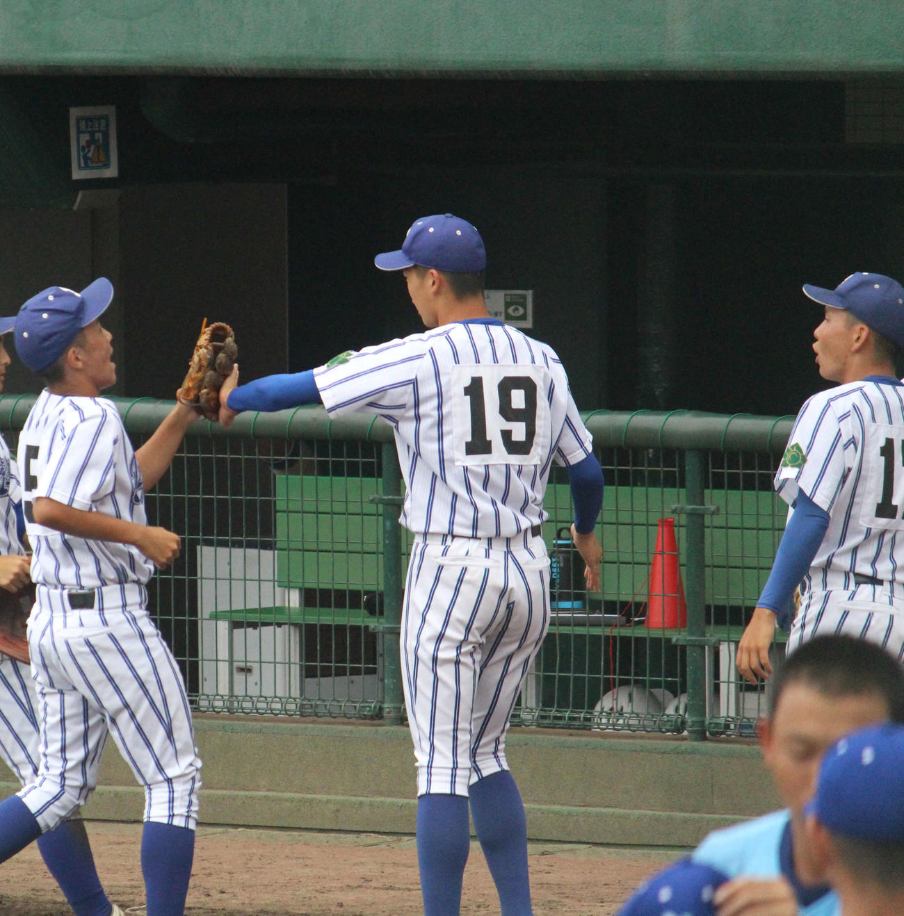 ベンチ前でチームメートを笑顔で迎える立正大立正・内海瑛太投手（左から2人目）