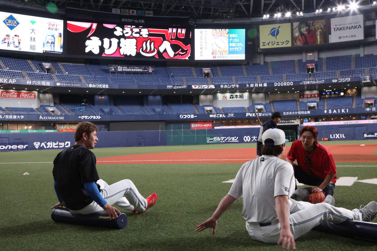 オリックス対日本ハム　15時50分、チームとは別便で移動したとみられる日本ハム加藤（左）と伏見はストレッチ（撮影・西尾就之）