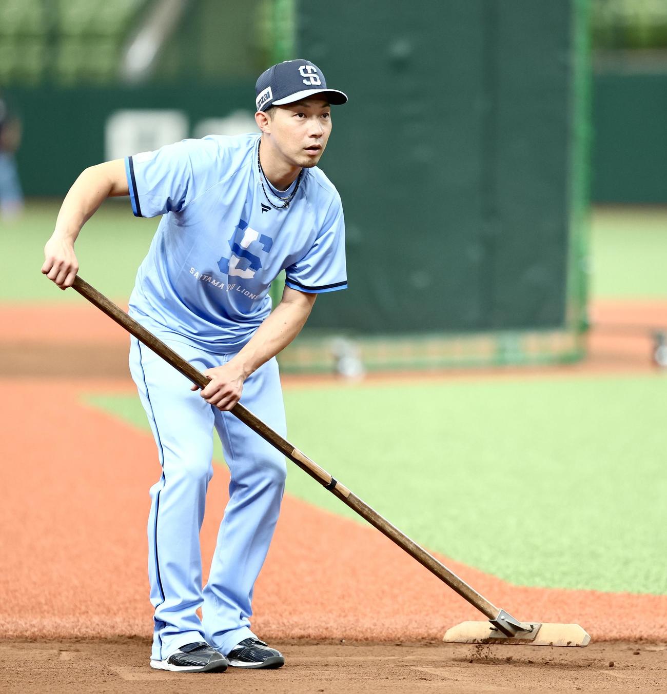 西武対ロッテ　試合前、土を整備する西武熊代外野守備・走塁コーチ（撮影・河田真司）