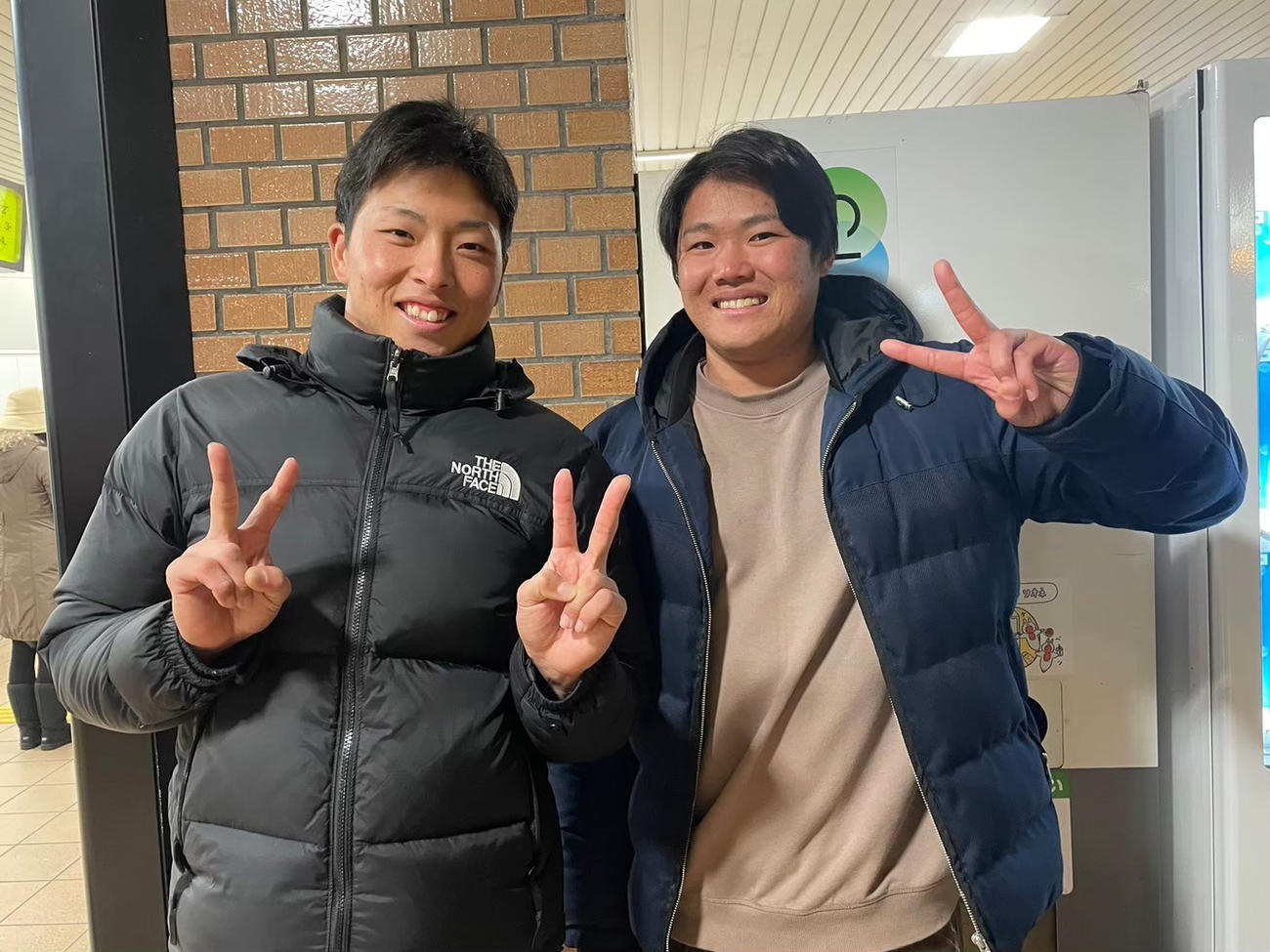 今年1月、母校の後輩と写真に収まる、広島の高（写真右）