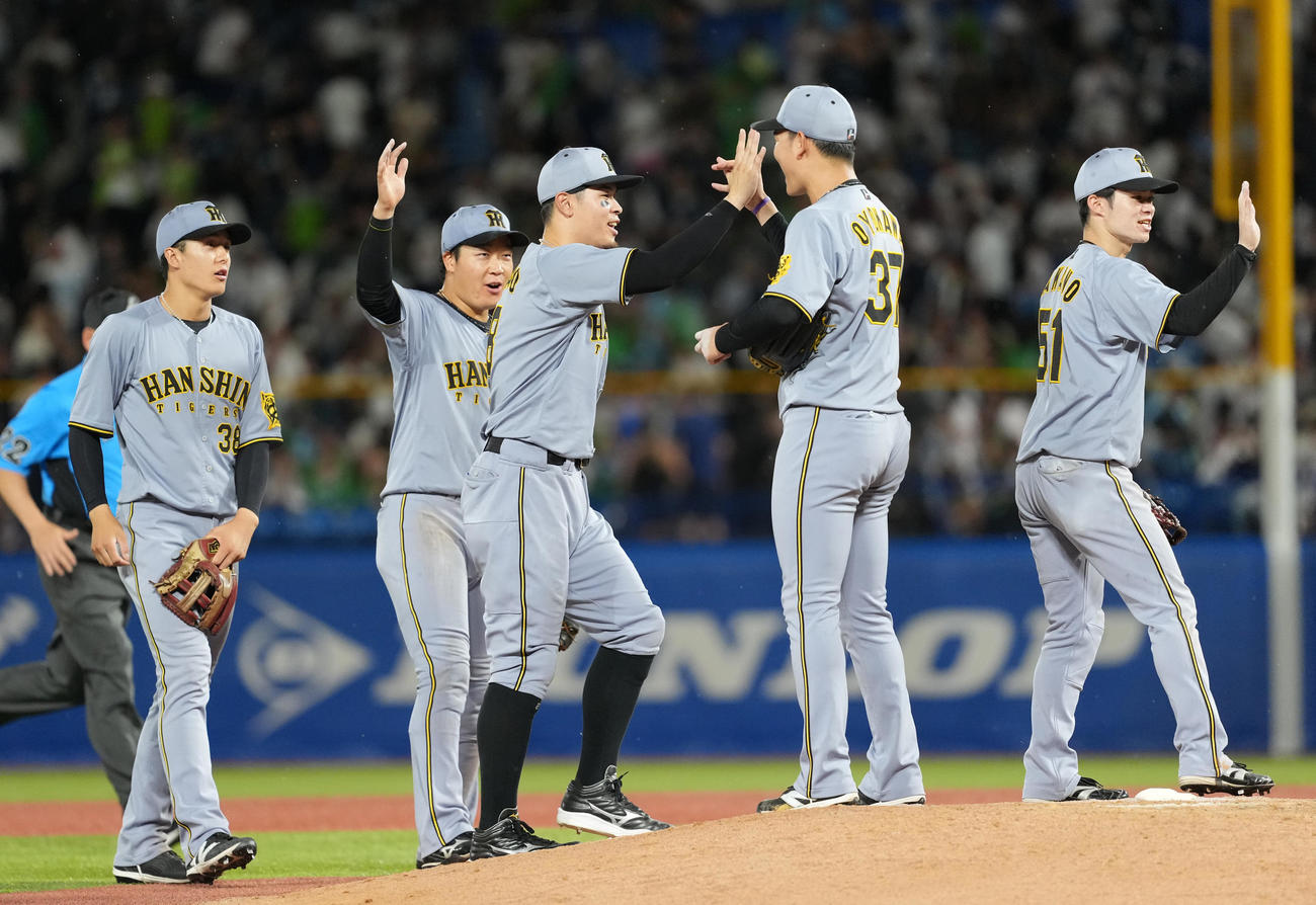 ヤクルト対阪神　延長戦を制し笑顔でタッチを交わす阪神佐藤輝（左から3人目）と及川（同4人目）（撮影・清水貴仁）
