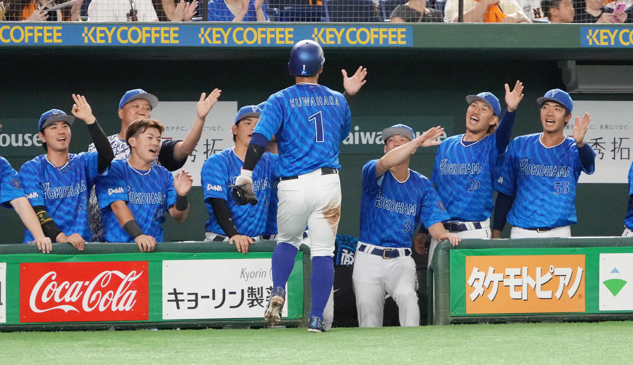 巨人対DeNA 1回表DeNA2死三塁、宮崎の先制遊撃適時内野安打で生還した桑原（中央）はベンチのナインの祝福を受ける（撮影・小沢裕）