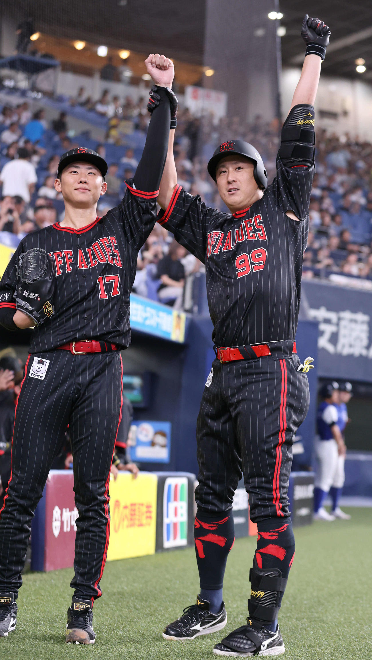 オリックス対日本ハム　3回裏オリックス2死、杉本（右）は本塁打を放ち、曽谷の手を取って昇天ポーズを決める（撮影・西尾就之）