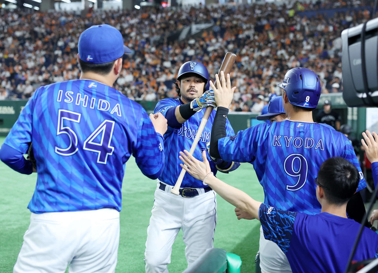 巨人対DeNA 6回表DeNA1死一、三塁、宮崎（中央）は右犠飛を放ちベンチ前でタッチ（撮影・鈴木正人）