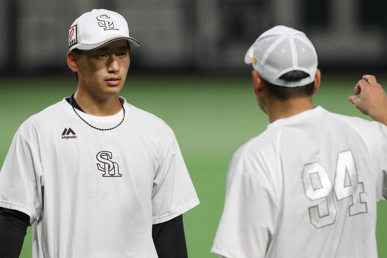 キャッチボールを終えた前田悠は倉野コーチの話を真剣な表情で聞く（撮影・梅根麻紀）