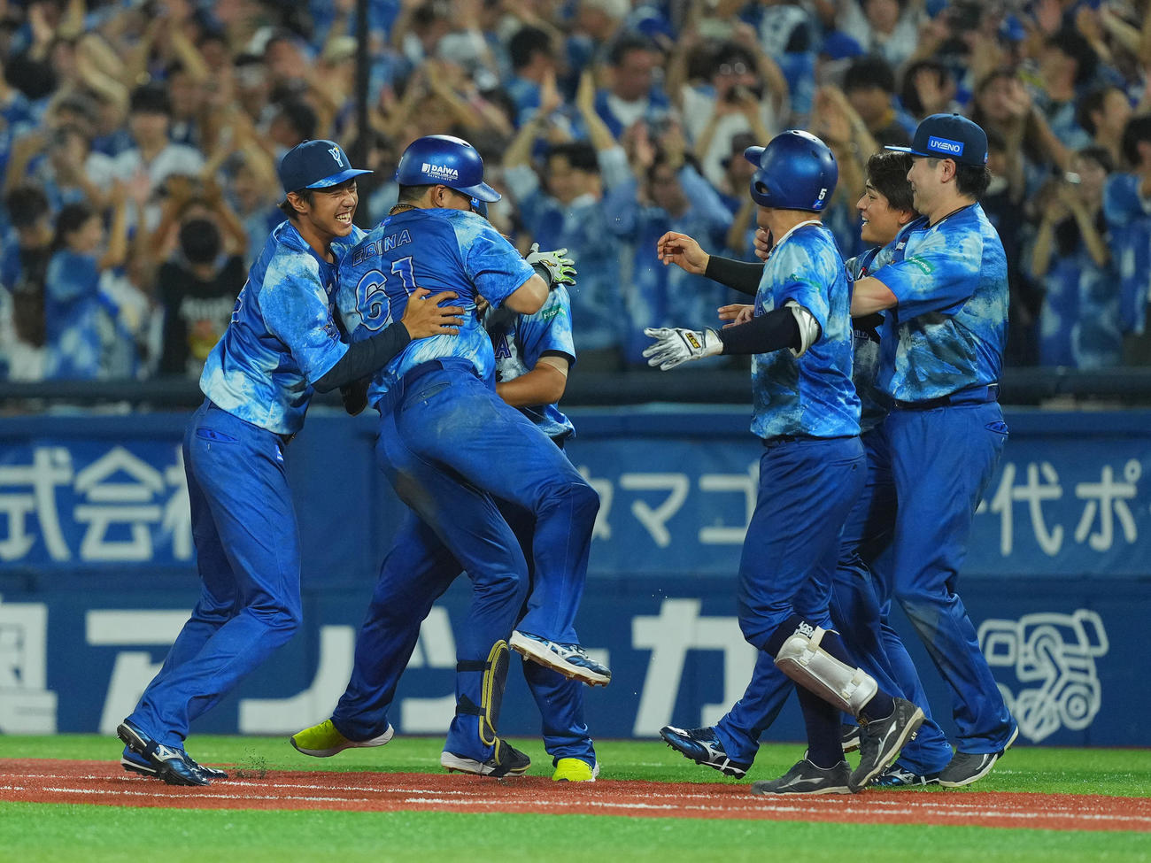 DeNA対広島　9回裏DeNA無死満塁、サヨナラの左犠飛を放ち、手荒い祝福を受ける蝦名（左から2人目）（撮影・菅敏）