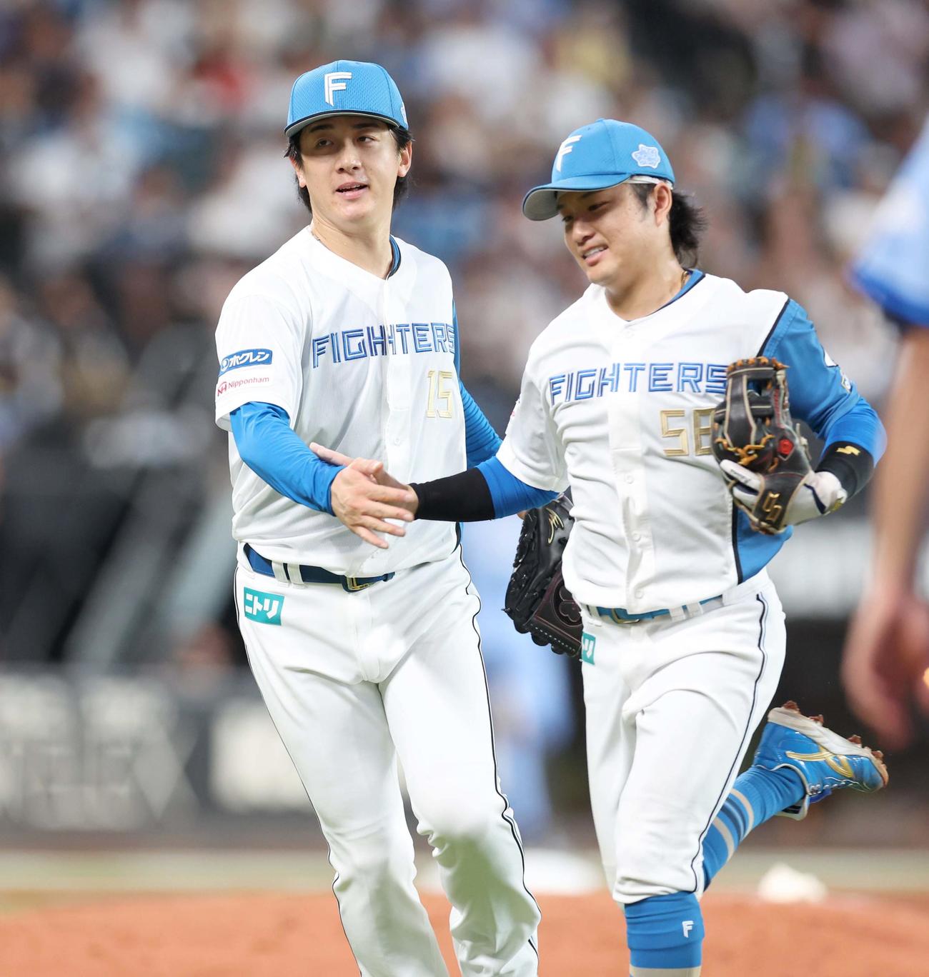 日本ハム対西武　5回表、無失点に抑え奈良間（右）とタッチする北山（撮影・黒川智章）