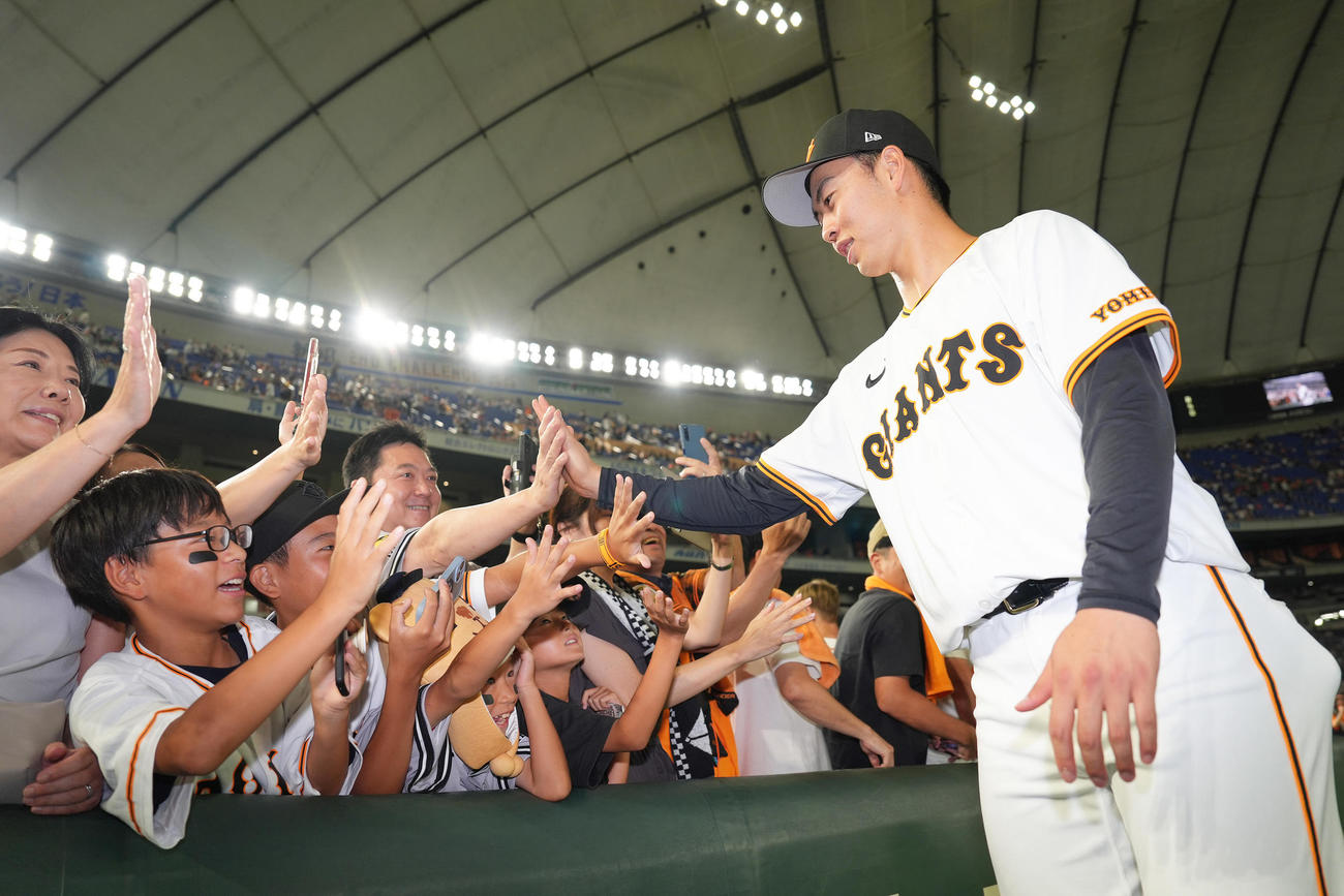 巨人対ヤクルト　プロ初勝利を挙げた巨人森田はファンと笑顔でタッチを交わす（撮影・足立雅史）