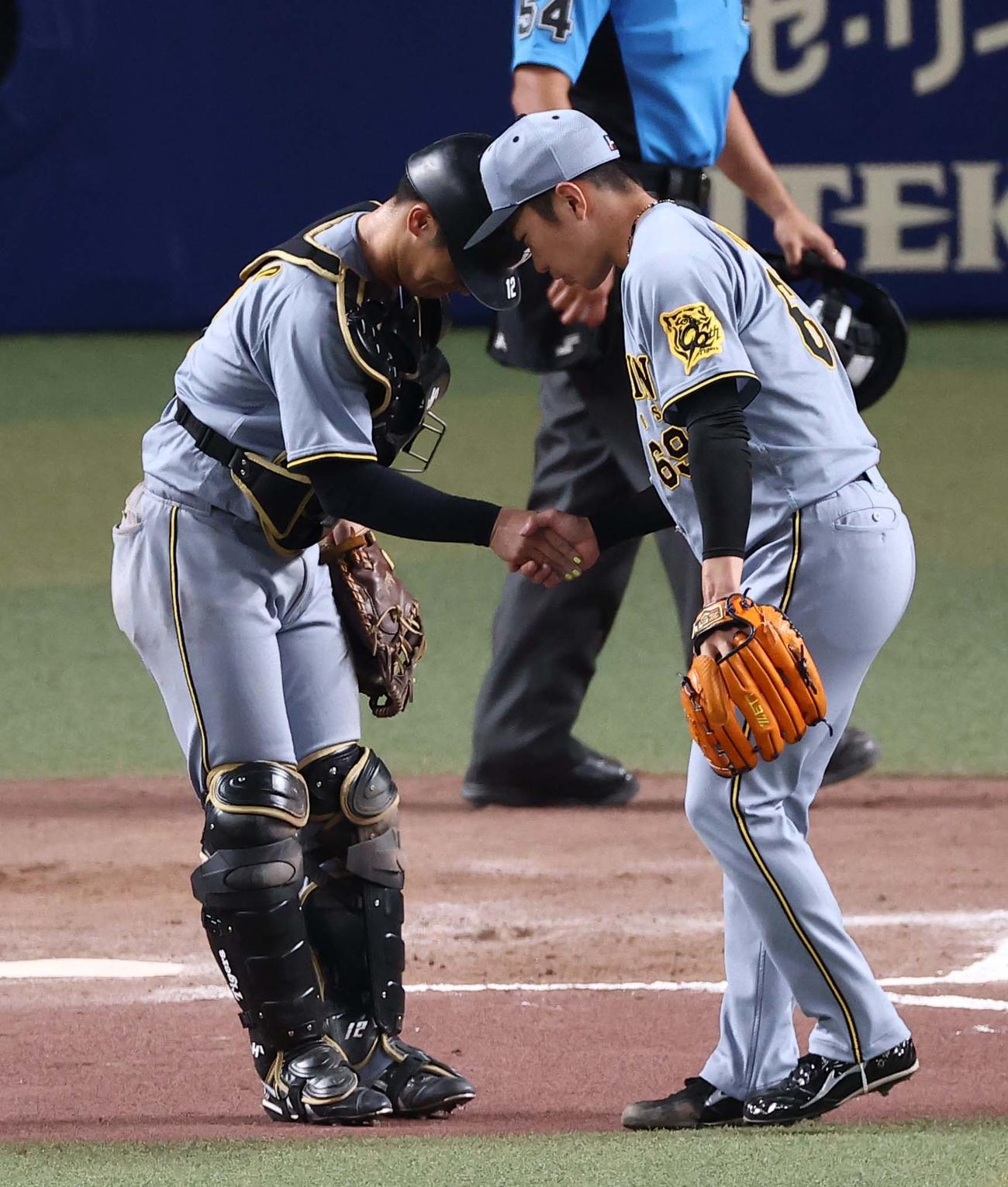 中日対阪神　中日に勝利した石井（右）は坂本と握手を交わす（撮影・上田博志）