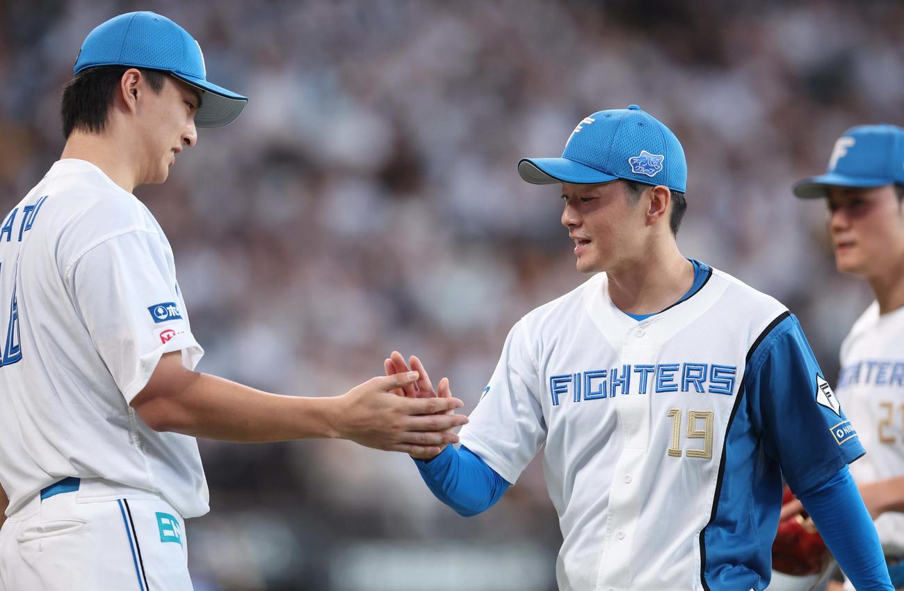 日本ハム対西武　7回表、ピンチをしのいだ2番手の玉井（右）は出迎えた達とタッチする（撮影・黒川智章）