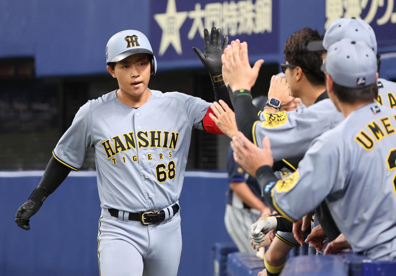 中日対阪神　2回表阪神1死、中川は左越えにプロ1号本塁打を放ち、ベンチ前で祝福を受ける（撮影・西尾就之）