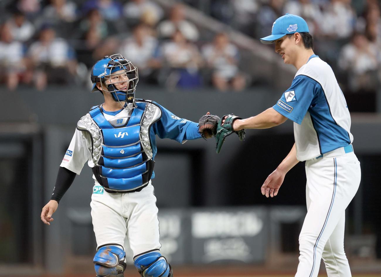 日本ハム対西武　3回表、無失点に抑えグラブタッチする梅林（左）と達（撮影・黒川智章）