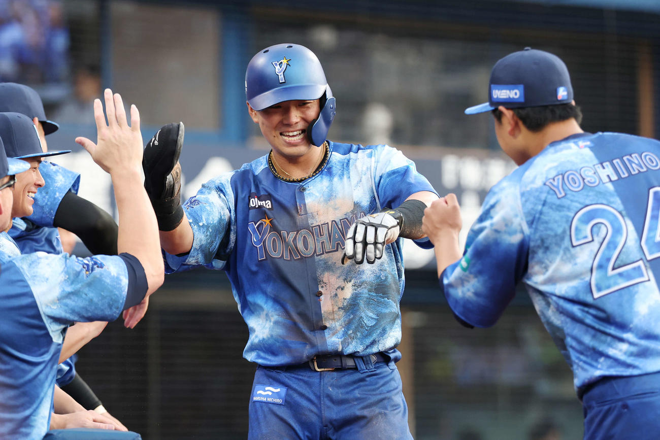 DeNA対広島　1回裏DeNA1死一、三塁、森の野選で生還し吉野（右）らと笑顔でタッチを交わす蝦名（撮影・宮地輝）