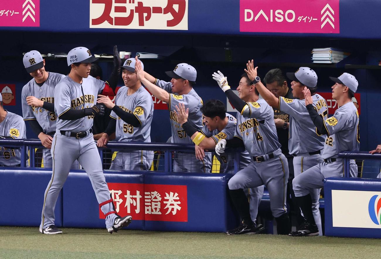 中日対阪神　2回表阪神1死、プロ初本塁打を放った中川は出迎えたナインとハイタッチをする（撮影・上田博志）