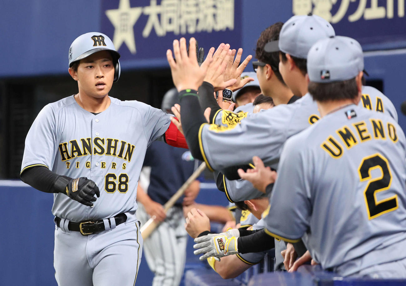 中日対阪神　2回表阪神1死、中川は左越えにプロ1号本塁打を放ち、ベンチ前で祝福を受ける（撮影・西尾就之）