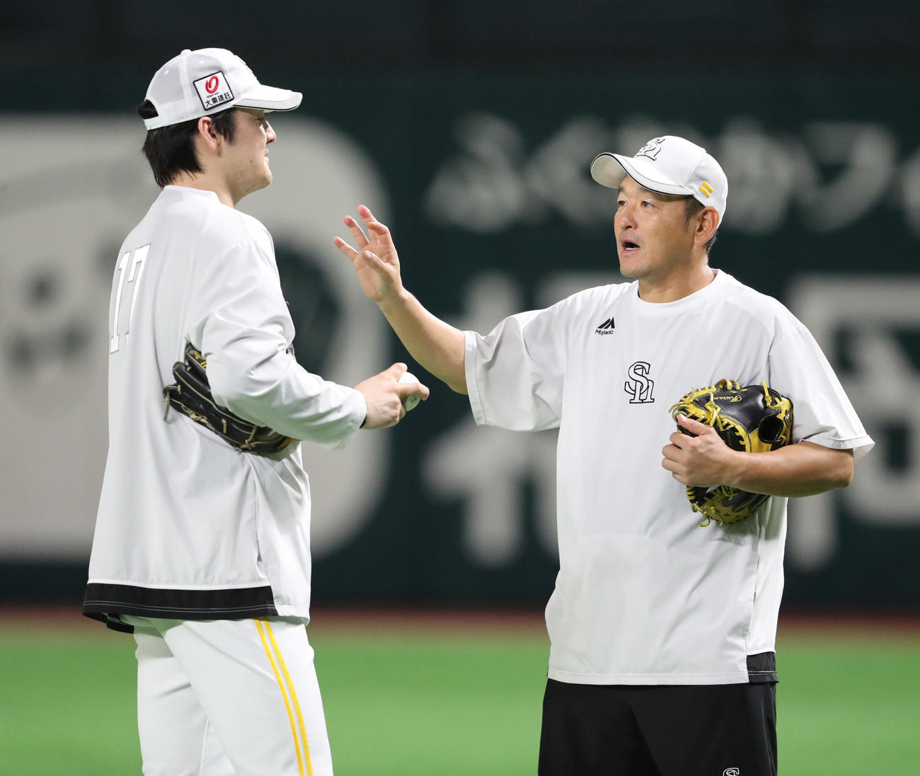 キャッチボールを終えた有原航平（左）は倉野コーチと話をする（撮影・梅根麻紀）