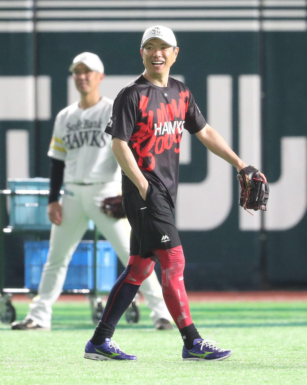 打撃練習中、外野で笑顔を見せる小久保監督（撮影・梅根麻紀）