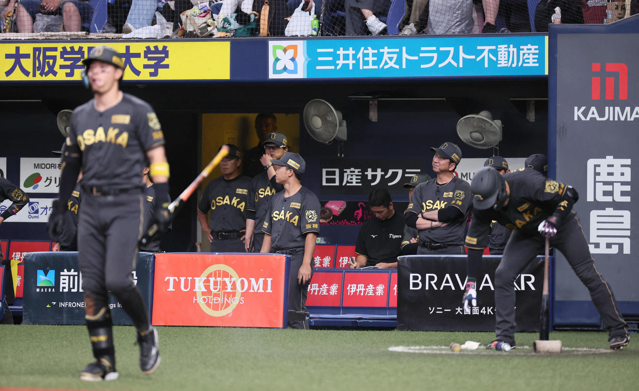 阪神対ヤクルト　11回裏阪神2死一、三塁、打席に向かう佐藤輝（左）とベンチで敬遠かな？と首をかしげる藤川監督（右後方）（撮影・宮崎幸一)