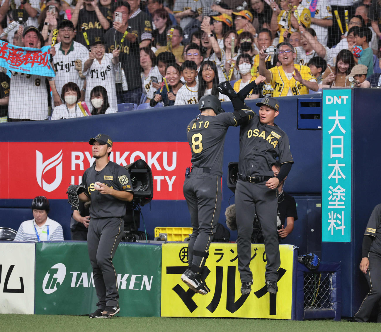 阪神対ヤクルト　4回裏阪神2死、佐藤輝（中央）は右越え先制本塁打を放ち、森下とジャンピングタッチ。左は伊藤将（撮影・宮崎幸一)