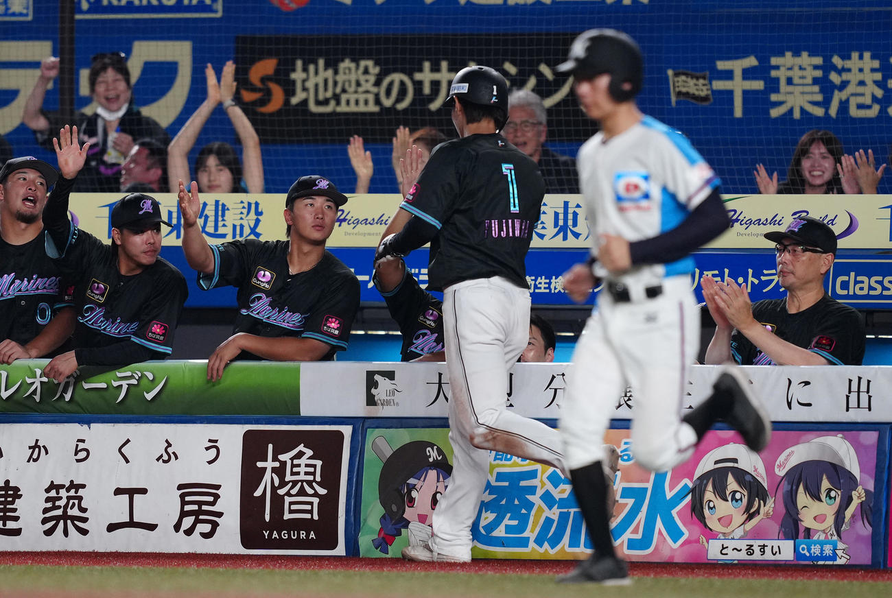 ロッテ対オリックス　5回裏ロッテ1死二塁、西川の左適時二塁打で生還した藤原（中央）を迎える吉井監督（右）（撮影・鈴木みどり）