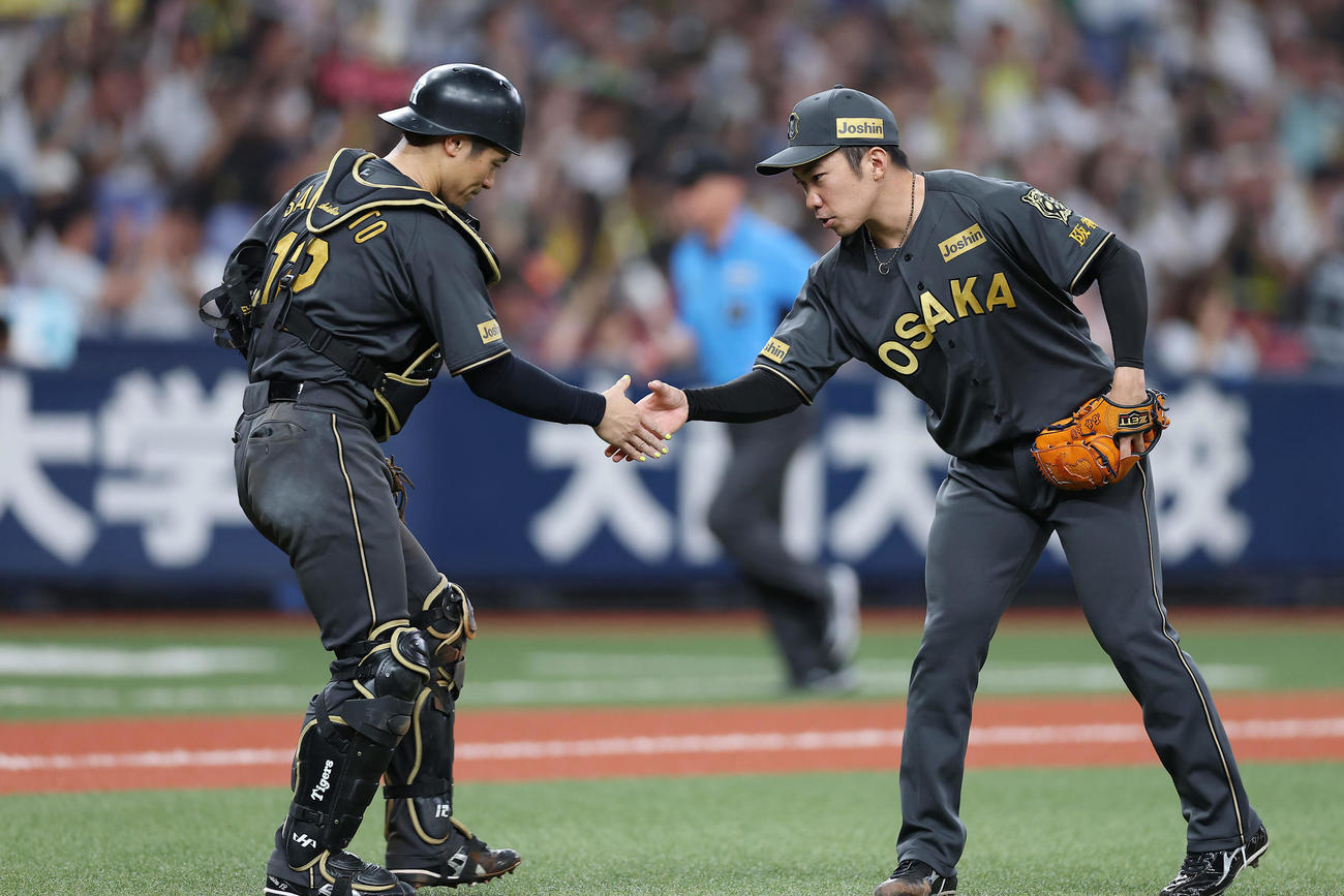 阪神対ヤクルト　ヤクルトに勝利し、握手を交わす阪神坂本誠志郎（左）と石井（撮影・前田充）