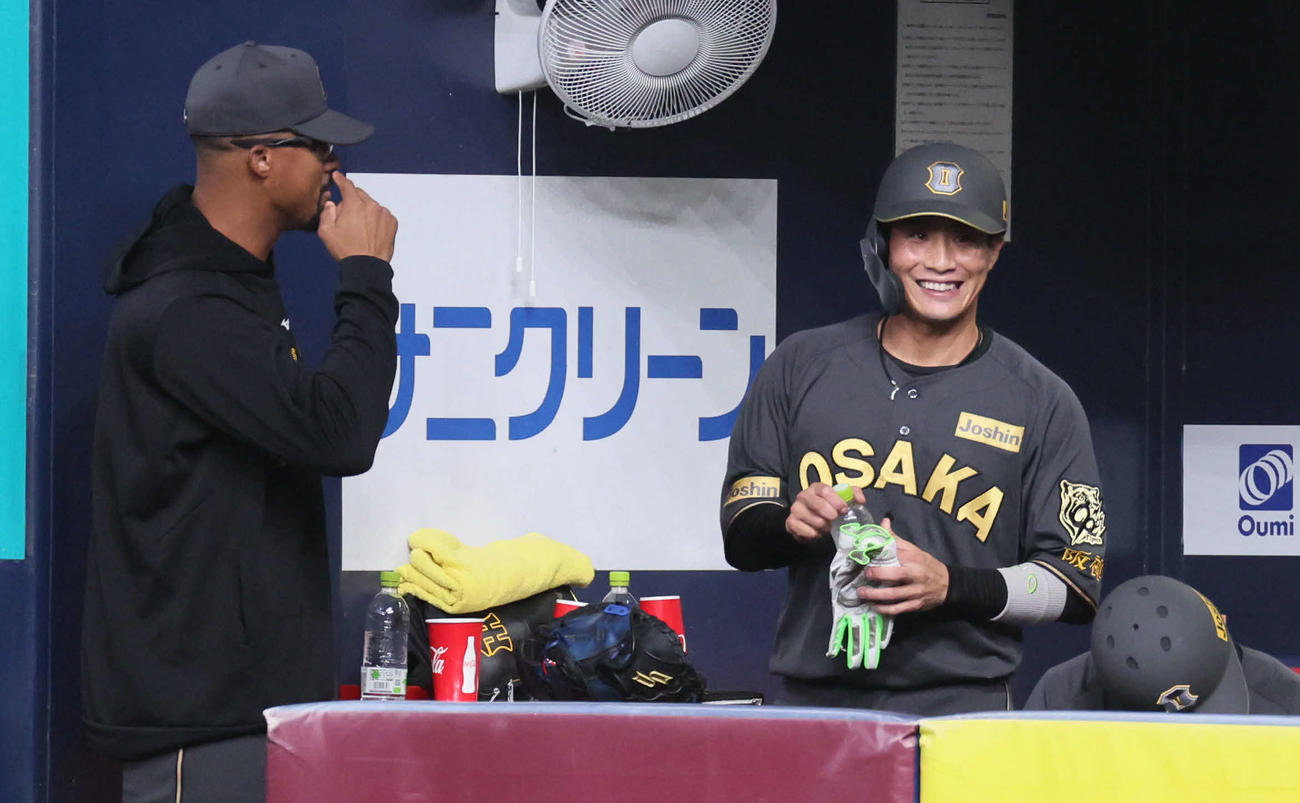 阪神対ヤクルト　8回裏阪神2死満塁、押し出し四球を選んだ木浪（右）は投手交代の間にベンチに戻り笑顔を見せる（撮影・宮崎幸一)